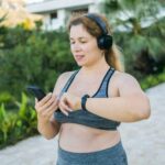 A woman wearing a fitness tracker checking her progress