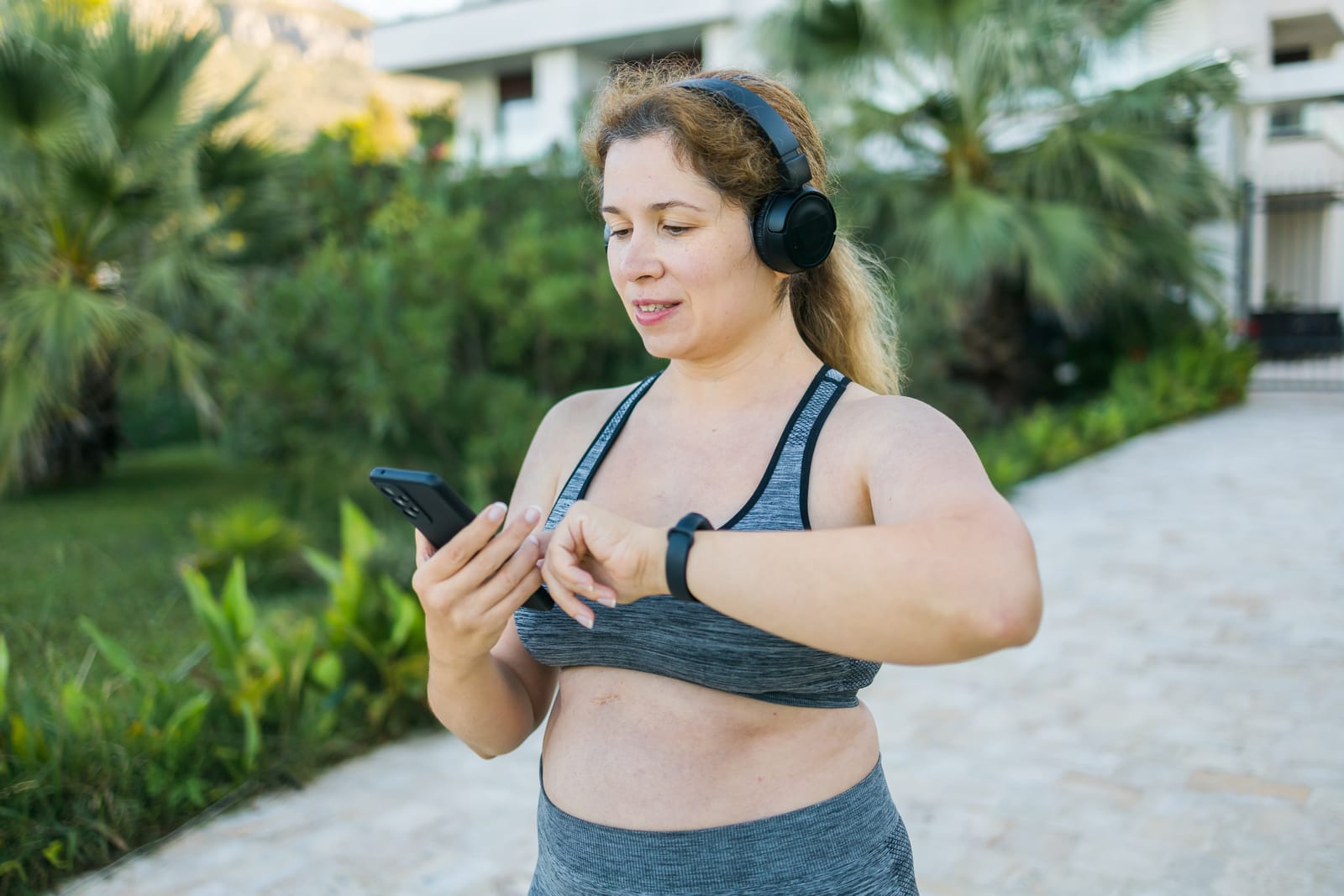 A woman wearing a fitness tracker checking her progress